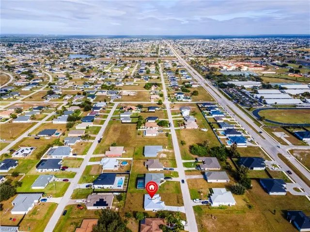 Aerial view of property and surrounding area featuring nearby suburban area