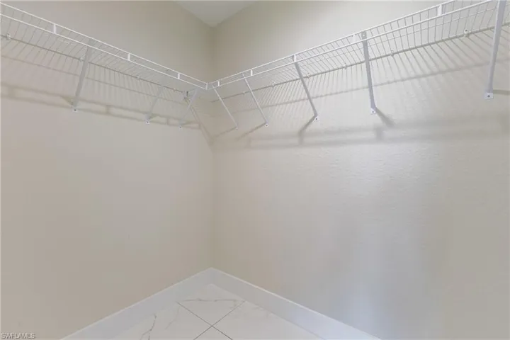 Spacious closet with light marble finish flooring