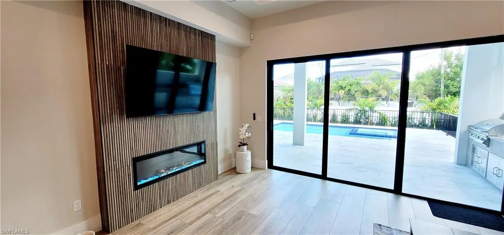 Doorway to outside featuring wood finished floors and a glass covered fireplace