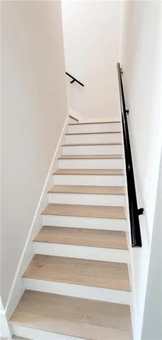 Staircase featuring wood finished floors