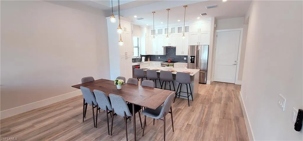 Dining area with light wood finished floors and recessed lighting