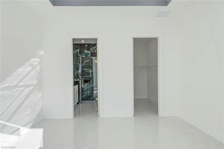 Unfurnished bedroom featuring a spacious closet and ensuite bathroom