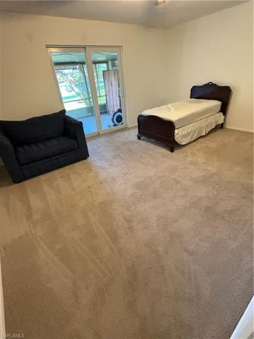 Bedroom with access to outside, carpet, and a textured ceiling