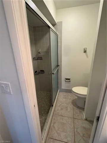Bathroom featuring a shower stall and toilet