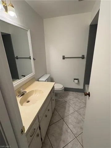 Half bathroom with vanity and light tile patterned floors