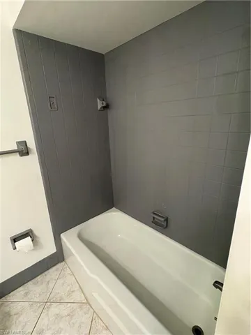 Bathroom featuring light tile patterned flooring and baseboards