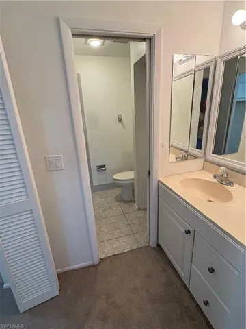 Bathroom featuring vanity and dark carpet
