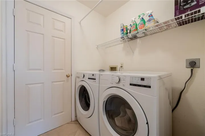 Laundry room with light tile patterned flooring and washing machine and dryer