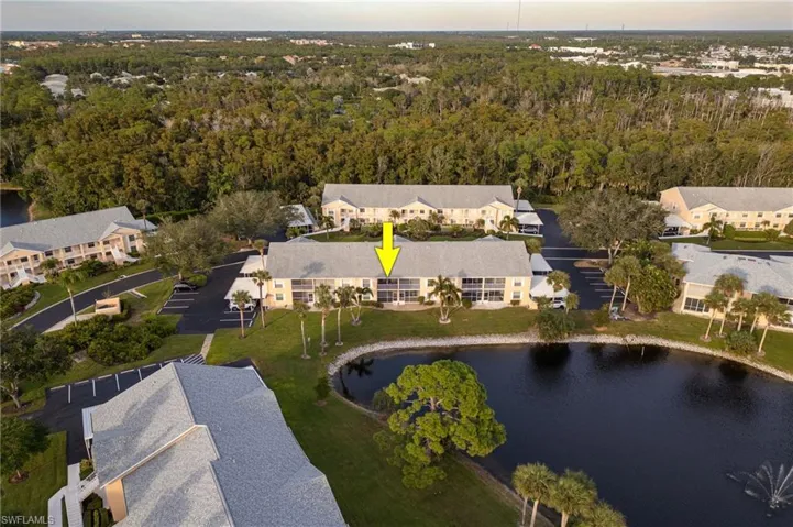 Aerial view of property and surrounding area featuring a large body of water and a heavily wooded area