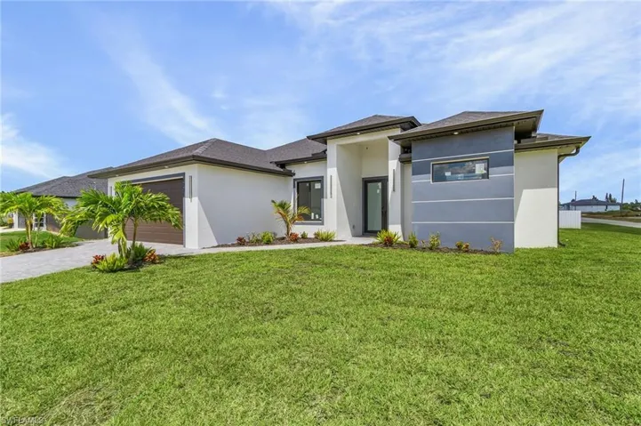 Prairie-style home with a garage and a front lawn