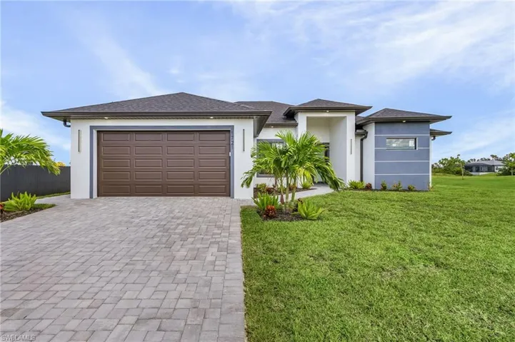 View of front facade featuring a front yard and a garage