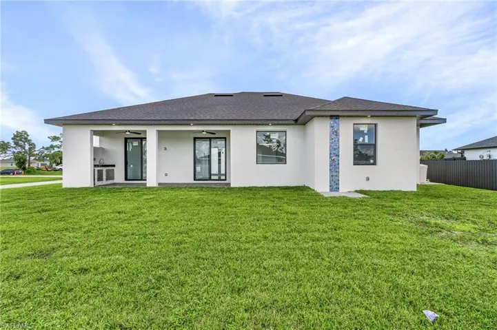 View of front facade with ceiling fan and a front yard