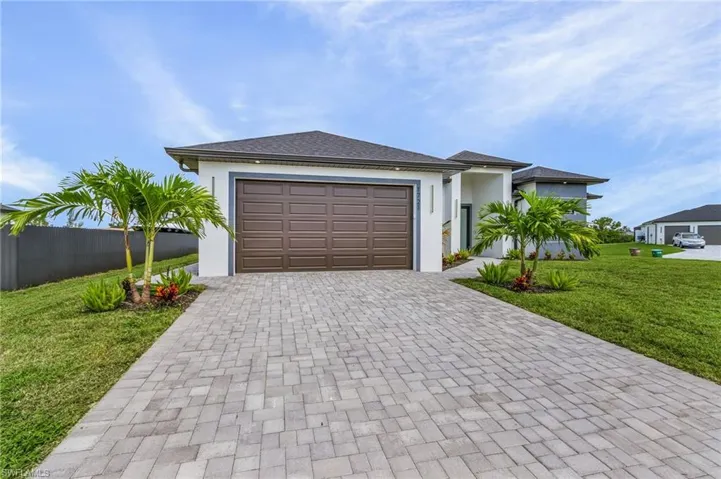 View of front of property with a garage and a front lawn