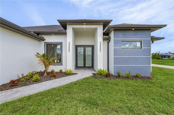 View of front of property featuring a front yard and french doors