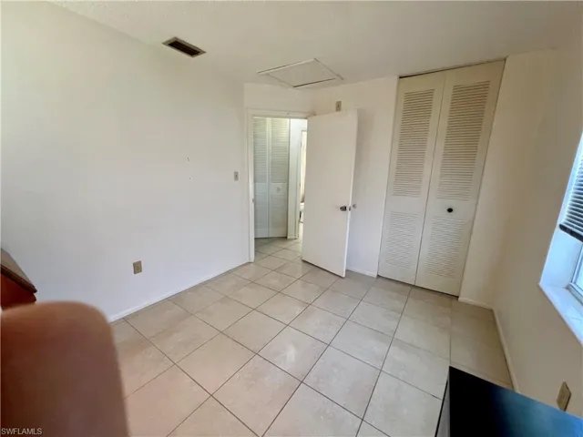 Tiled bedroom featuring a closet