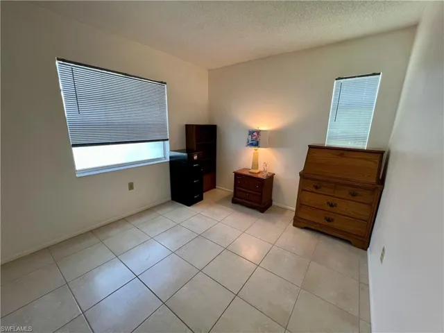 Unfurnished bedroom with a textured ceiling and light tile patterned floors