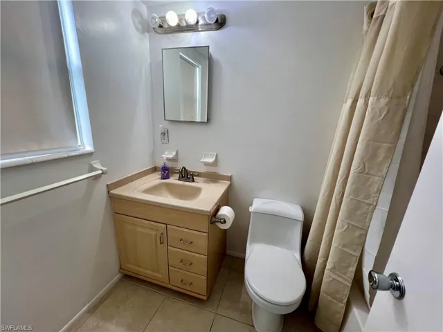 Bathroom with tile patterned flooring, vanity, and toilet