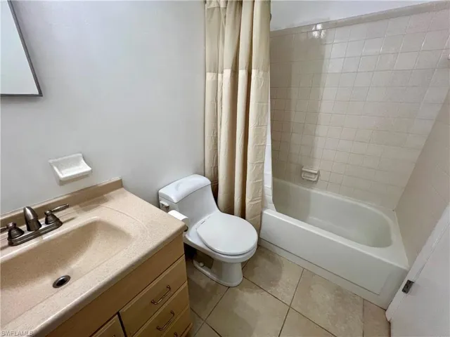 Full bathroom featuring tile patterned flooring, shower / bath combo, vanity, and toilet