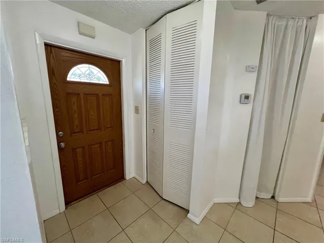 Entryway featuring a textured ceiling and light tile patterned floors