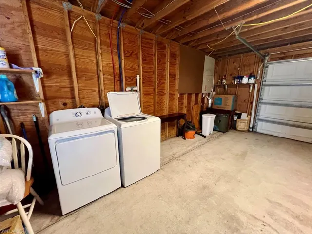 Laundry area featuring washing machine and dryer in oversized garage