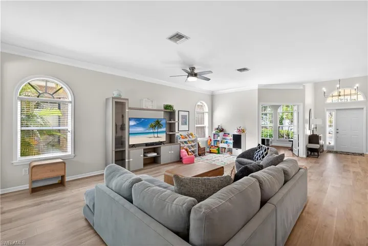 Sun-filled and spacious living room with palladium windows and beautiful vinyl tile flooring