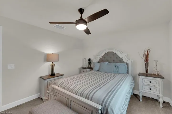 Bedroom with light carpet and a ceiling fan