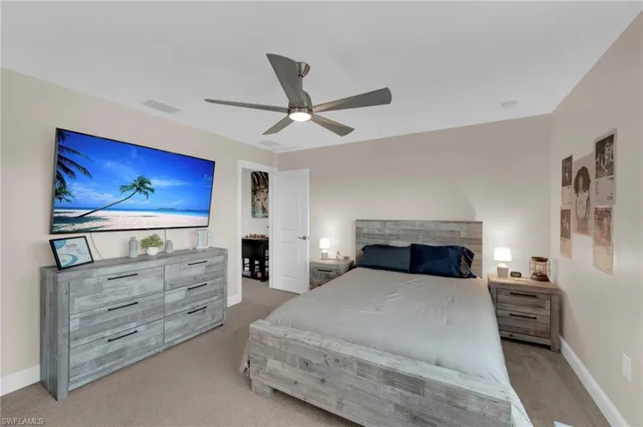Bedroom with light colored carpet and a ceiling fan