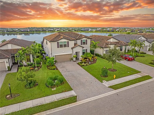 Mediterranean / spanish-style house with decorative driveway, stucco siding, a yard, a tiled roof, and an attached garage
