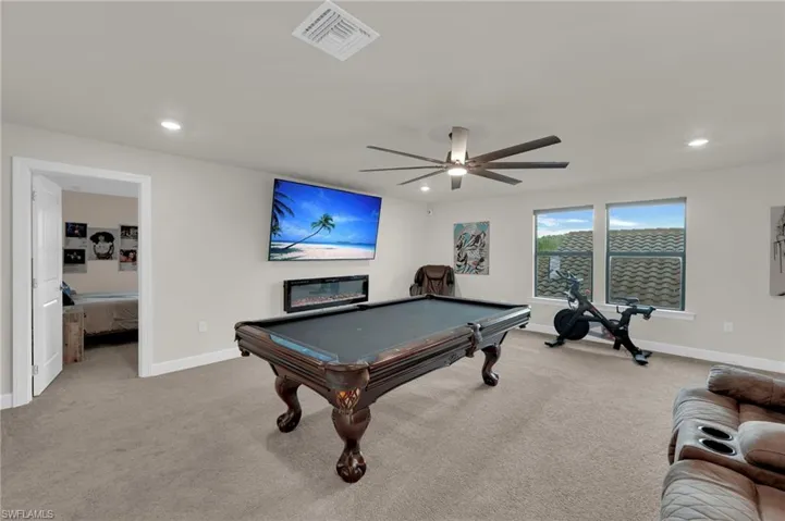 Recreation room featuring billiards, light carpet, recessed lighting, a glass covered fireplace, and a ceiling fan