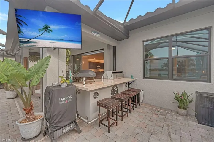 View of patio / terrace with exterior kitchen and a sunroom