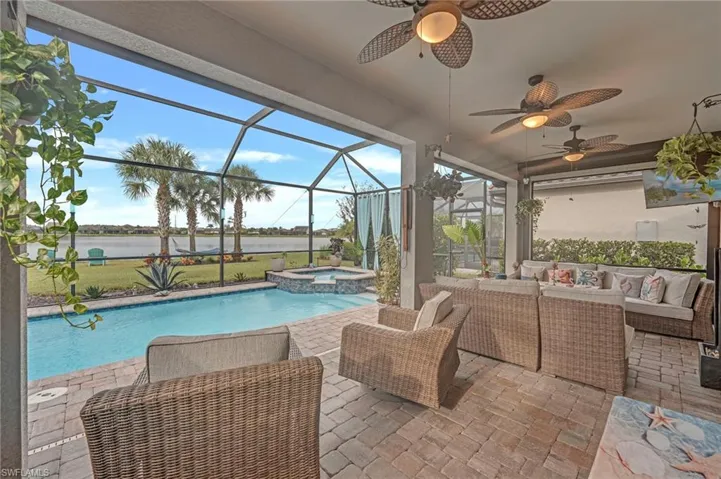 View of pool featuring a patio area, a sunroom, a lanai, and a pool with connected hot tub