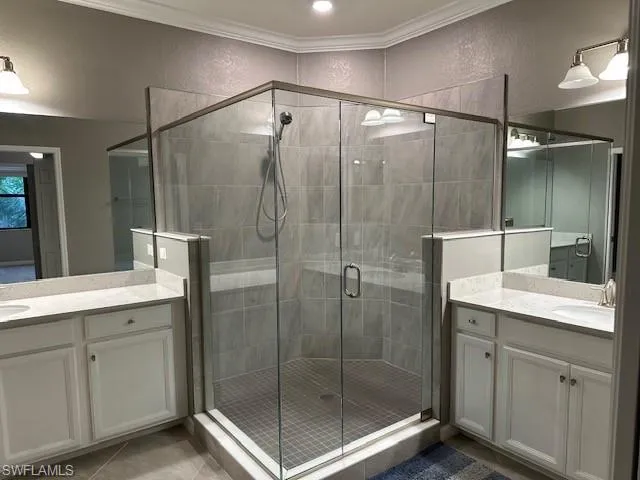 Master Bathroom featuring dual sinks and an enclosed shower, crown molding, vanity, and tile patterned floors