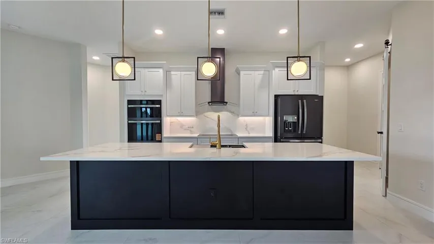 Kitchen with black stainless steel appliances, recessed lighting, and quartz countertops