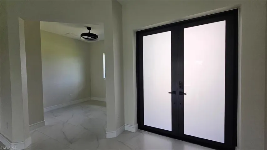 Foyer entrance with light marble finish flooring and french doors