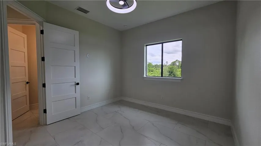 Spare room # 2 featuring light marble-like finish floors
