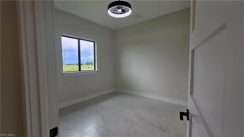 Spare room #1 featuring light marble-like finish floors