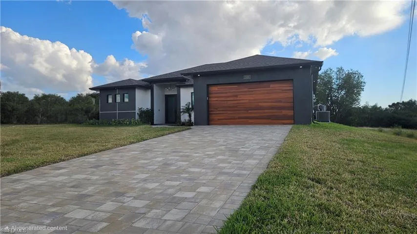 View of front of home featuring a front yard, stucco siding, decorative driveway, and an attached garage