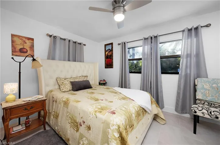 Bedroom with light tile patterned flooring and a ceiling fan