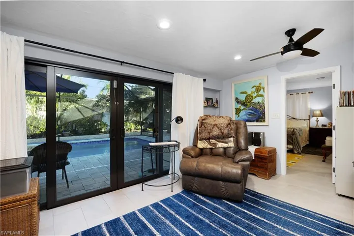 Living area with light tile patterned flooring, a ceiling fan, and recessed lighting