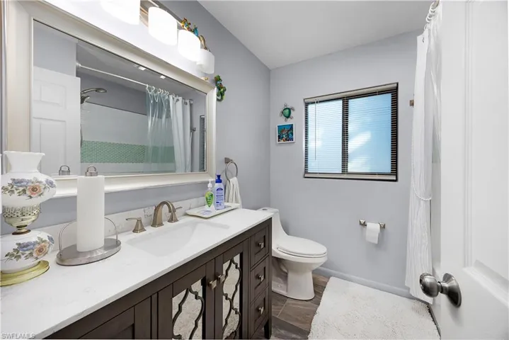 Full bath with curtained shower and vanity