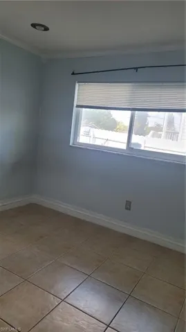 Spare room with light tile patterned flooring and ornamental molding