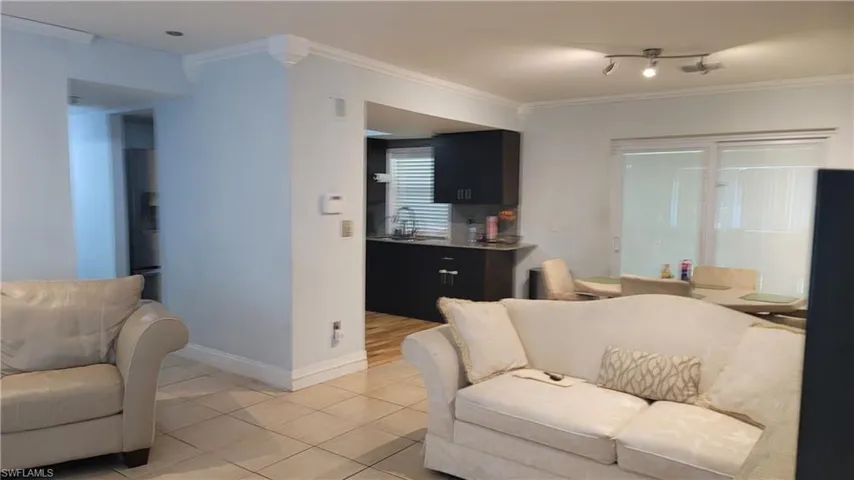 Living area featuring crown molding and tile patterned flooring