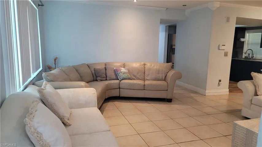 Living room with ornamental molding and tile patterned floors