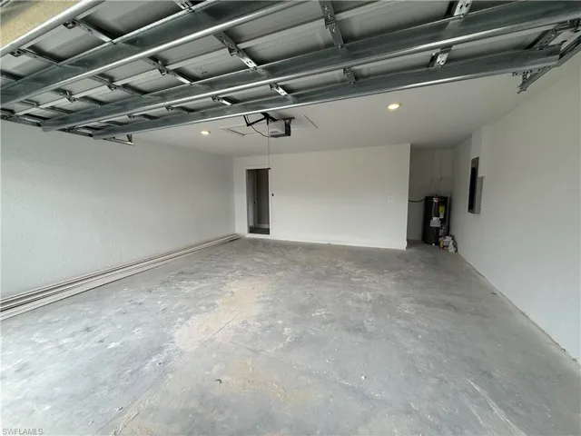 Garage featuring a garage door opener and water heater