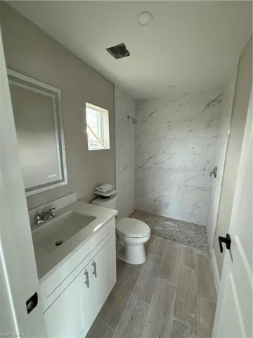 Bathroom with vanity, toilet, and walk in shower