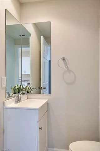 Half Bathroom downstairs featuring vanity and toilet
