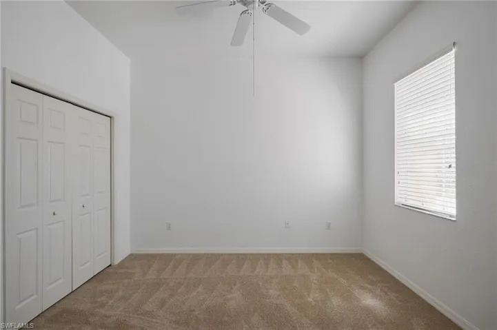 Unfurnished bedroom with a closet, carpet, and ceiling fan