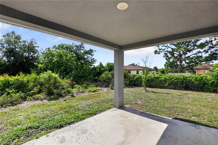 Covered outdoor patio with a concrete slab, recessed lighting, and a partial privacy wall