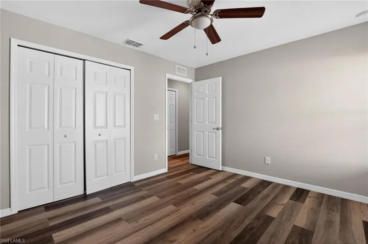 Room featuring wood-finish flooring, neutral wall tones, and white trim