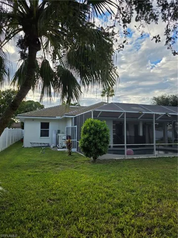 Back of property featuring a lanai, a sunroom, and stucco siding